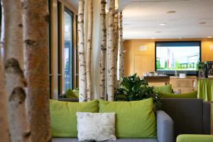 ein Wohnzimmer mit einem Sofa und einigen Bäumen in der Unterkunft Hotel Heffterhof in Salzburg
