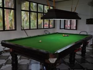 a green pool table in a room withwindows at Wild Grass Resort in Port Blair