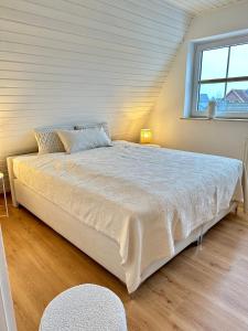 een groot bed in een kamer met een raam bij Ferienhaus Sandbar direkt am Deich in Spieka-Neufeld