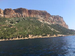 a mountain on the side of a body of water at Zina in Cassis