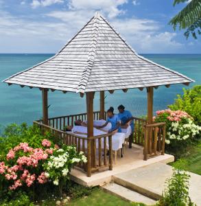 two people sitting at a table under a gazebo at Calabash Cove Resort and Spa - Adults Only in Gros Islet