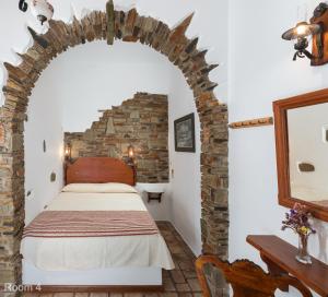 um quarto com uma cama e uma parede de tijolos em Voreades em Tinos