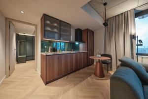 a kitchen and living room with a couch and a table at The Zipper Hotel und Apartments in Düsseldorf