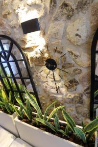 a clock on the side of a stone wall at Lilla Maria Guesthouse in Ayvalık