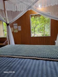 un grand lit dans une chambre avec une fenêtre dans l'établissement Thung Sen Tam Coc Chalets, à Ninh Binh