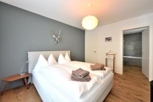 a bedroom with a white bed with two bags on it at Fontana in Arosa