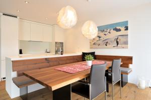 a kitchen with a wooden dining table and chairs at Fontana in Arosa