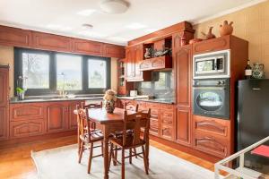 a kitchen with wooden cabinets and a table with chairs at Karaltzos LB00530 in Lezama