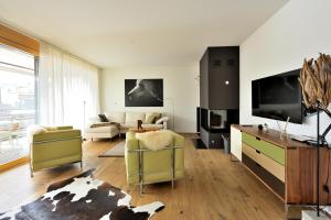 a living room with a couch and a tv at Fontana in Arosa