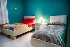 a bedroom with two beds and a blue wall at VILLA SOFIA in Montenero di Bisaccia
