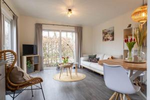 een woonkamer met een bank en een tafel bij Gezellig modern chalet midden op de Veluwe in Epe