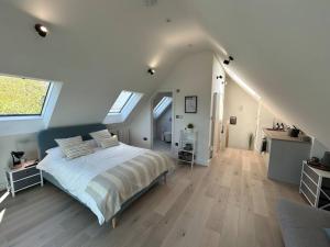 een slaapkamer met een groot bed op zolder bij The Nest in Uffington