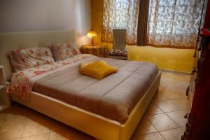 a bedroom with a bed with a yellow pillow on it at VILLA SOFIA in Montenero di Bisaccia