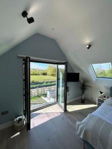 1 dormitorio con cama y ventana grande en The Nest, en Uffington