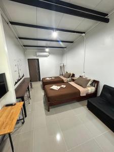 Zimmer mit 2 Betten, einem Tisch und Stühlen in der Unterkunft BIG BEN Residence in Kaeng Khoi