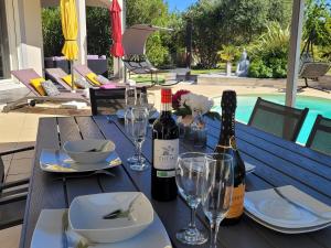 una mesa con dos botellas de vino y copas en Villa Jade en Lasserre-de-Prouille