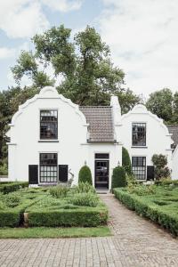 a white house with black windows and a driveway at Kasteel Engelenburg in Brummen