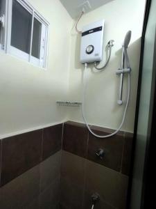 a shower in a bathroom with a hair dryer on the wall at Areezo Condo buhangin City Davao in Davao City