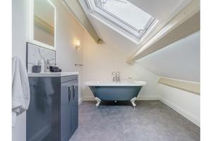 a bathroom with a tub and a sink and a skylight at luxury Farmhouse: Hot Tub & Garden in Soutergate