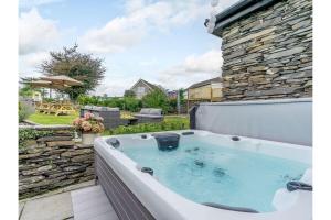 a jacuzzi tub sitting on a patio at luxury Farmhouse: Hot Tub & Garden in Soutergate