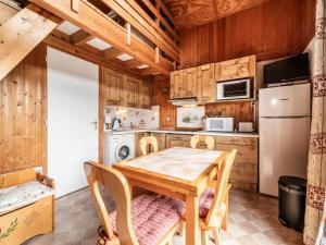 eine Küche mit Tisch und Kühlschrank in der Unterkunft Chalet mitoyen Les Gets 6 pers. - Balcon Sud, Garage, Wi-Fi, Animaux admis - FR-1-671-139 in Les Gets + 17 Fotos