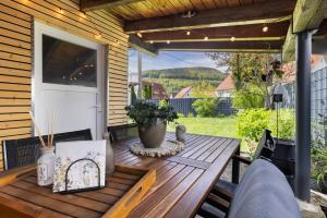 einen Holztisch auf einer Terrasse mit einem Fenster in der Unterkunft Ferienwohnung Mittenglück in Unterlenningen