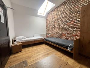 a room with a brick wall and two beds at Centrum Dialogu Kultur in Węgrów