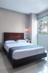 een slaapkamer met een groot bed en een raam bij Ribai Hotels Santa Marta in Santa Marta