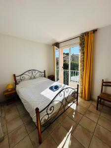 a bedroom with a bed and a large window at Petite villa au calme dans résidence avec piscine in Fréjus