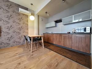 - une cuisine avec une table et des chaises en bois dans l'établissement ADLER Bed&Breakfast, à Łódź
