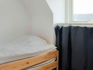 uma cama num quarto com uma janela em Holiday home Halmstad XI em Halmstad