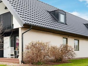 a white house with a black roof at Holiday home Halmstad XI in Halmstad