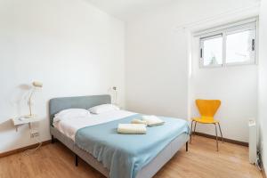 a bedroom with a bed with a chair and a window at BLife Bandaya private apartment in Faro