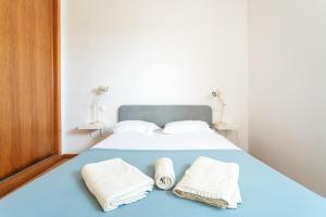 a bedroom with a bed with two towels on it at BLife Bandaya private apartment in Faro