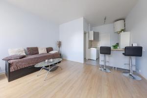 ein Wohnzimmer mit einem Sofa und einem Tisch in der Unterkunft L'Escale Clermontoise - studio 26m2 in Clermont-Ferrand