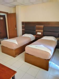 2 camas en una habitación con en Asokainn, en Mettuppālaiyam