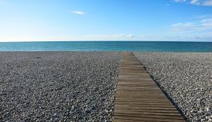 un camino de madera que conduce al océano en una playa en Le Verdier, en Dieppe