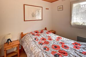 a bedroom with a bed with red flowers on it at Les Chênes Rouges - Appt avec piscine partagée in Gérardmer