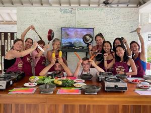 聖吉吉的住宿－Anggrek Putih Homestay & Cooking Class，一群人站在桌子旁吃着食物