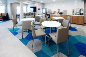 a waiting room at a dental office with tables and chairs at Microtel Inn & Suites Springville in Springville