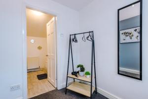 a room with a mirror and a table with a plant at A Comfortable 1-Bedroom Apartment - Sleeps 2 in Warrington