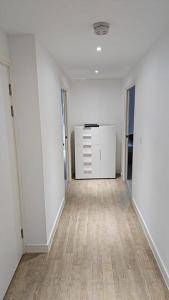 an empty room with white walls and wooden floors at Greenwich Glamorous 2-Bed Apartment in London