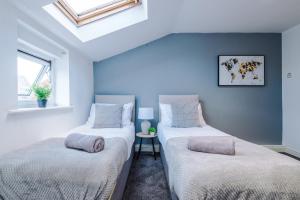 two twin beds in a room with a skylight at A Comfortable 1-Bedroom Apartment - Sleeps 2 in Warrington