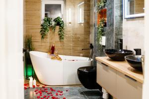 a bathroom with a large tub and two sinks at Prestige ApartHotel Brasov in Braşov +61 photos