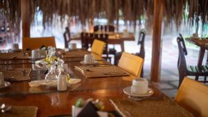 un comedor con mesas y sillas de madera, mesa y sillón en Hotel Bahia Cartagena en Cartagena de Indias