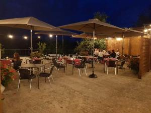 a group of tables and chairs with umbrellas at night at Auberge d'ici et d'ailleurs in Cressensac