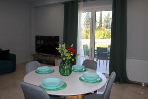 ein Wohnzimmer mit einem weißen Tisch und einer Vase aus Blumen in der Unterkunft Dream Houses in Perama
