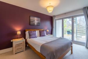 a bedroom with a bed and a large window at Muntjac Lodge in Somerford Keynes