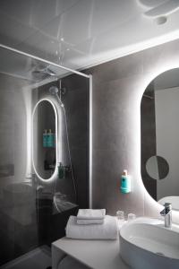 uma casa de banho com um lavatório e um espelho em Novotel Bordeaux Mérignac em Mérignac