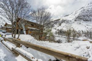 a log cabin in the snow with a fence at Chalet Les moulins in Bonneval-sur-Arc